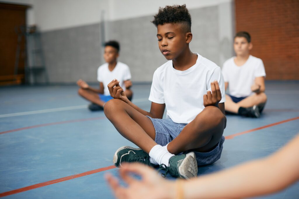 boy meditating in gym